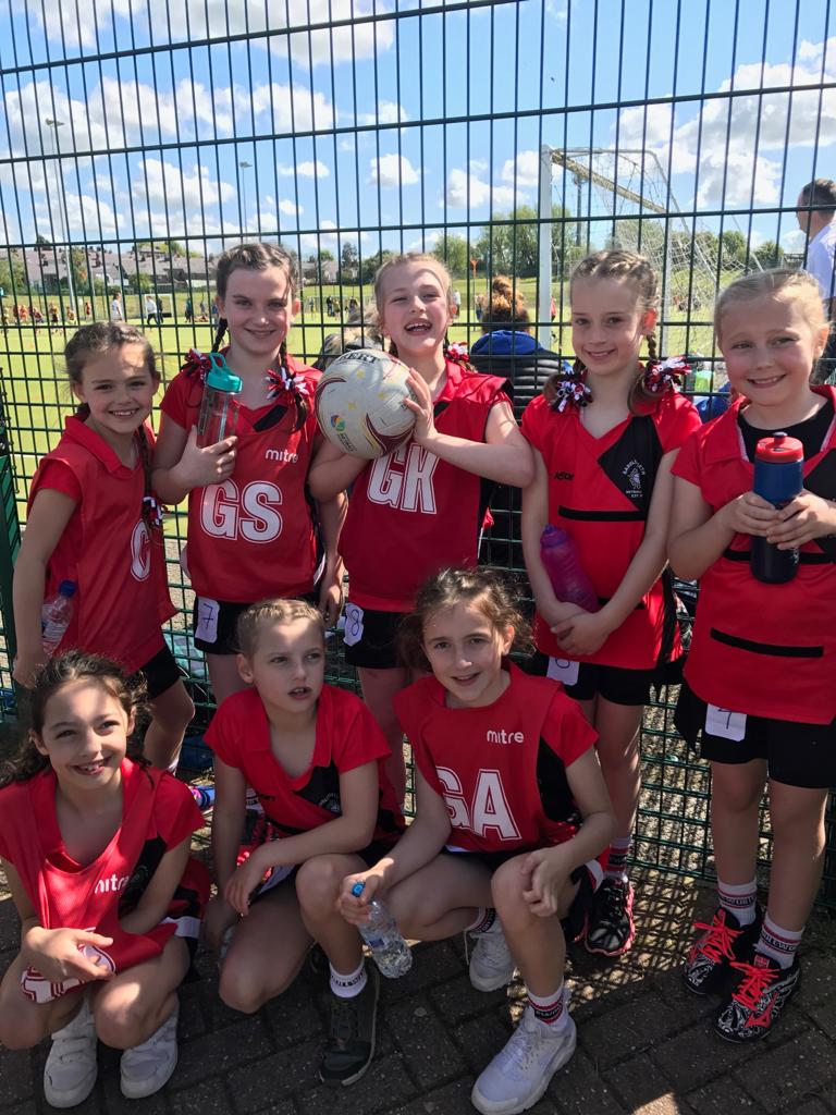 Saddleworth Netball Club players in red kit at a tournament